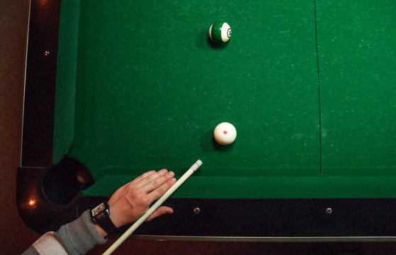 Young man playing billiards.