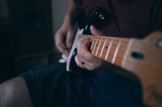 Guy playing on eletric guitar with amp