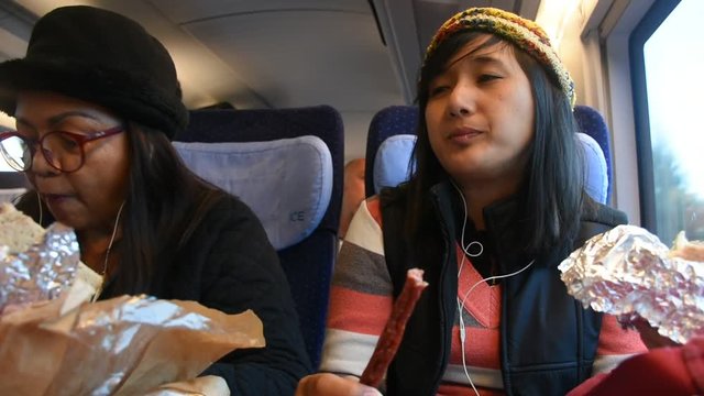 Asain thai women mother and daughter sit and eating food homemade on train from germany go to travel at Paris city on September 5, 2017 in Paris, France