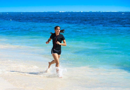 Latin girl running in caribbean shore beach