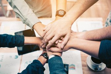 Close up of  group of business people joining their hands together in unity.