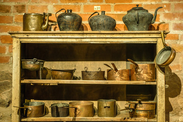 Old retro metal tableware on wooden shelf