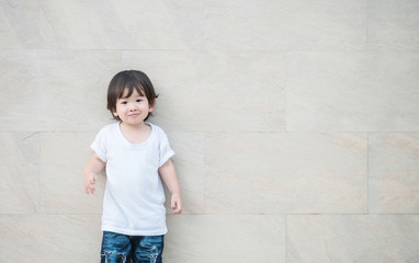 Naklejka na ściany i meble Closeup happy asian kid with smile face on marble stone wall textured background with copy space