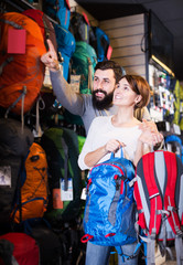 Couple choosing rucksack in store