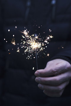 Man holding sparkler in his hand