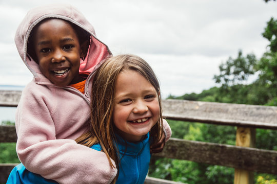 African American girl piggyback on a caucasian friend