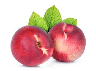 two whole of nectarine peach with green leaves isolated on whitie background