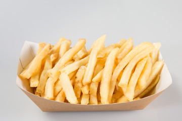 French fries in carton in kraft blank paper fry box on white background isolated