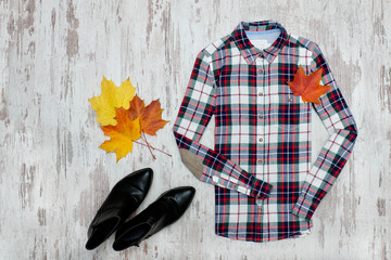 Checkered shirt, black shoes, maple leaves. Fashionable concept