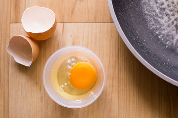 Fresh eggs in a cup and egg shell, pan