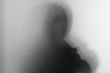 Shadow blur of horror man screaming mask.Dangerous man behind the frosted glass.Mystery man.Black and white picture.Blur picture.Add effects noise and grain.Halloween. - 177882216