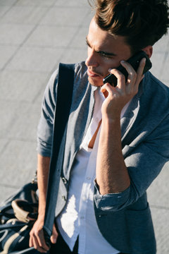 Young man talking with his phone in a street