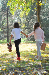 Little boy and girl holding hands and walk in park. Boy and girl in love going in autumn park