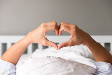 Woman is showing a gesture by hand in heart shape