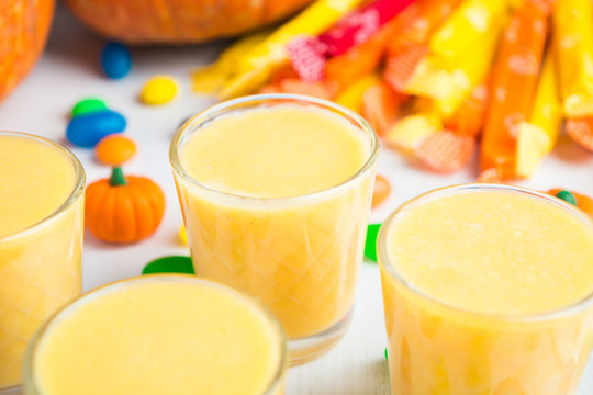 Closeup view of smoothie in glass with candies on background