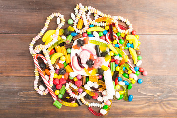 Circle of many candies over brown wooden table