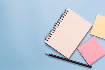 top view of blank notebook pencil and notice sticker on light blue background with copy space. memo...