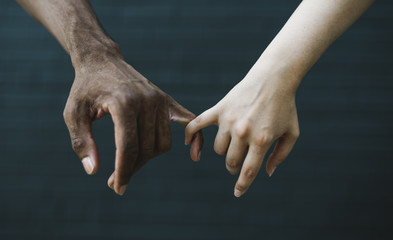 White and Black holding hands close up