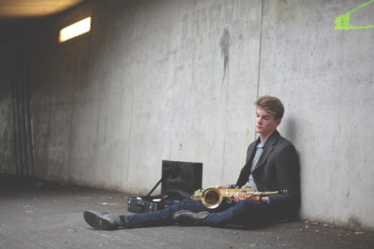 Young tenor saxophonist in an urban tunnel