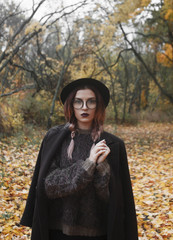 A girl supports a hand glasses on a background the forest