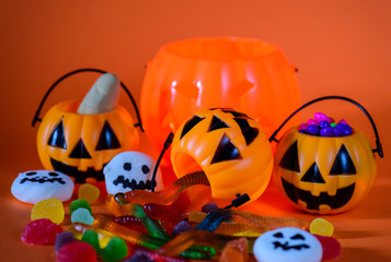 Halloween pumpkin with sweets candies including worms jelly and ghost marshmallow.