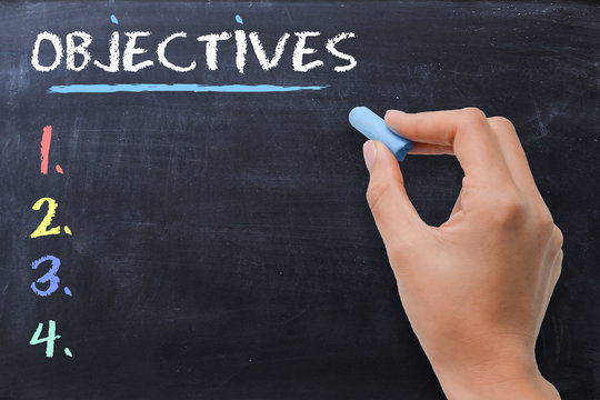 Define business or strategic objectives written by woman on chalkboard