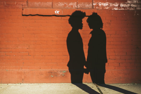 Gay couple shadow on brick wall