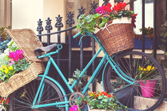Vintage blue bicycle with flower baskets, on a city street