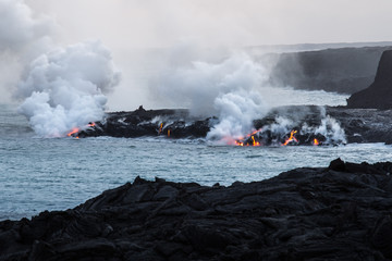 Fototapeta na wymiar Molten lava flowing into the sea to Pacific Ocean on Big Island of Hawaii, USA