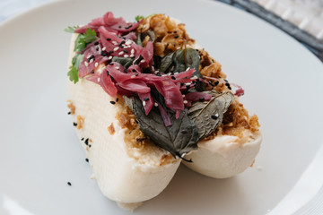 Close up photo of a traditional bao steamed bun with pork fillin