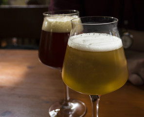 Two glasses of beer on a table. - 177892221