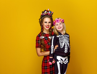 mother and child in halloween costume on yellow background