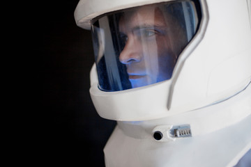 Fototapeta premium Astronaut in a helmet looks down. Fantastic space suit. Exploration of outer space.