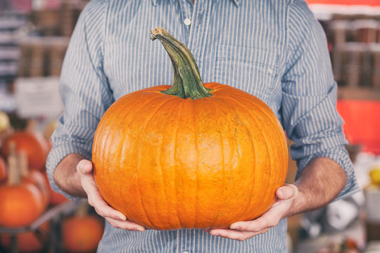 Market: Man Holding The Perfect Halloween Pumpkin