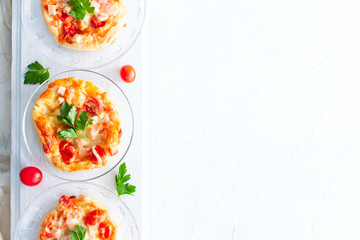 Mini pizza topped with cherry tomatoes ,ham and cheese, copying space