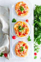Mini pizza topped with cherry tomatoes ,ham and cheese