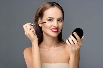 Obraz na płótnie Canvas young woman applying makeup