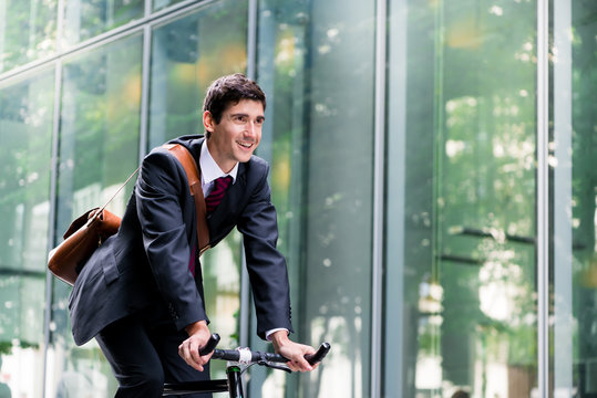Junger Arbeitnehmer pendelt zum Büro mit dem Fahrrad