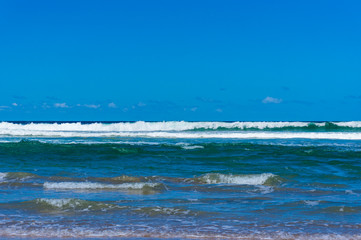 Fototapeta na wymiar Sunlit ocean waves and blue sky