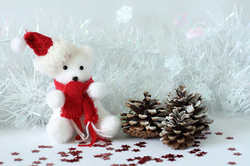 ourson polaire portant un bonnet et une écharpe rouge posé à coté de cadeaux pour décoration de fêtes de Noël