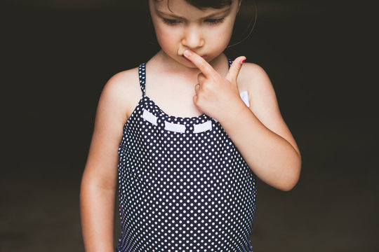 Serious girl wearing navy polka dot swim suit