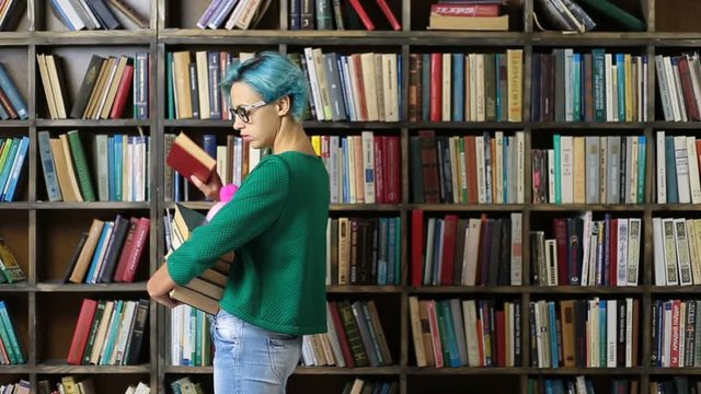 Female student choosing book on shelf in library