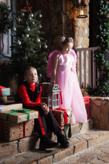 Boy and girl are sitting on the porch with gifts