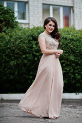 Portrait of a beautiful and gentle girl in elegant gown posing outdoor.