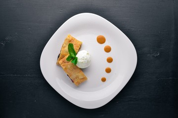 Apple Strudel with Ice Cream. On a wooden background. Top view. Free space for your text.