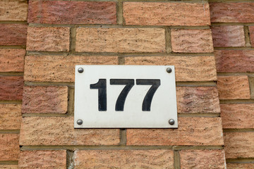 House number 177 sign fixed to wall