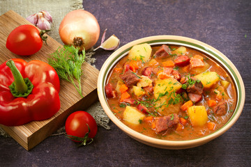 Tasty stew. Goulash soup bograch in a bowl and ingredients. Hungarian dish, horizontal