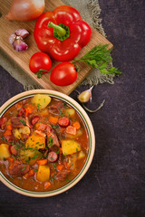 Tasty stew. Goulash soup bograch in a bowl and ingredients. Hungarian dish, view from above, top shot, vertical
