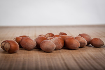 Hazelnuts on wooden table and white background