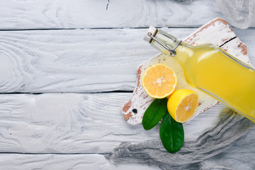 Fresh Lemons and Lemon Juice. On a wooden background. Top view. Free space for your text.